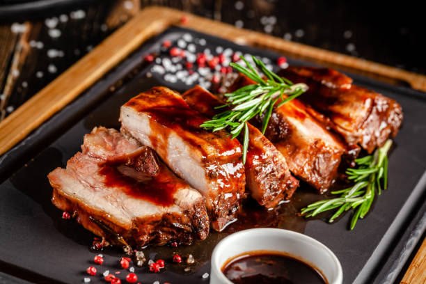 American food concept. Grilled pork ribs with grilled sauce, with smoke, spices and rosemary. Background image. copy space stock photo