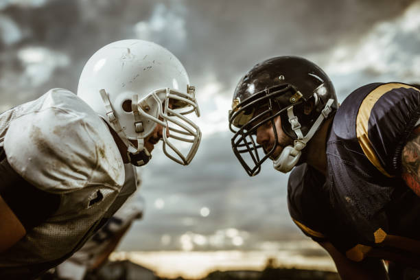 American football players confronting before the beginning of a match. Two American football players looking at each other on a beginning of the match. face to face stock pictures, royalty-free photos & images