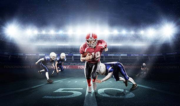 American football players in action on stadium with ball Young football players with a blue and red uniform in a stadium with fans american football player stock pictures, royalty-free photos & images