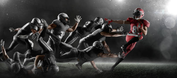 American football players in dark sport stadium American football players fights for the ball in dark sport stadium with fog. The winner is forging ahead american football player stock pictures, royalty-free photos & images
