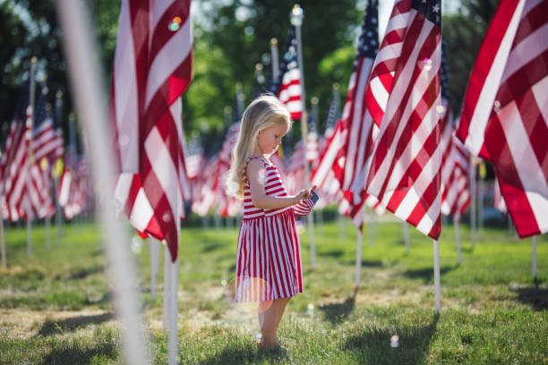 American girl in a field of flags stock photo