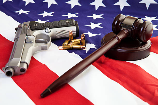 American Gun Laws Photo of gavel, gun, and bullets over an american flag. nra stock pictures, royalty-free photos & images