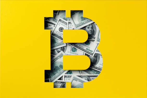 American one hundred dollar bill heap under paper cutout, Bitcoin icon stock photo