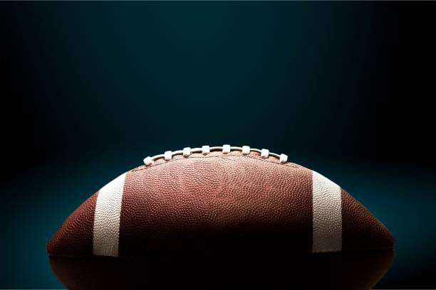 American. American football ball on background football stock pictures, royalty-free photos & images