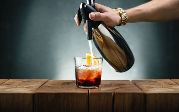 Americano cocktail and soda siphon Filling up the Americano cocktail with an oldsoda siphon. Campari, sweet vermouth and club soda siphon stock pictures, royalty-free photos & images