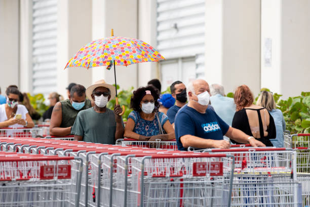estadounidenses usan máscaras faciales para detener la propagación de la pandemia de coronavirus covid 19 - editorial fotografías e imágenes de stock