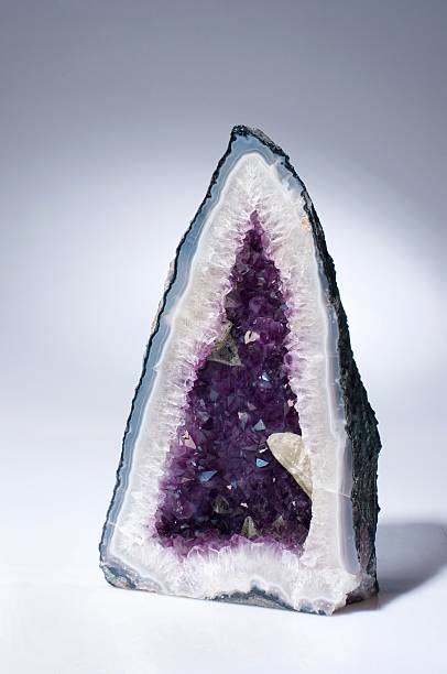 Amethyst Geode A beautiful amethyst geode also known as amethyst-grotto on a white background. amethyst stock pictures, royalty-free photos & images