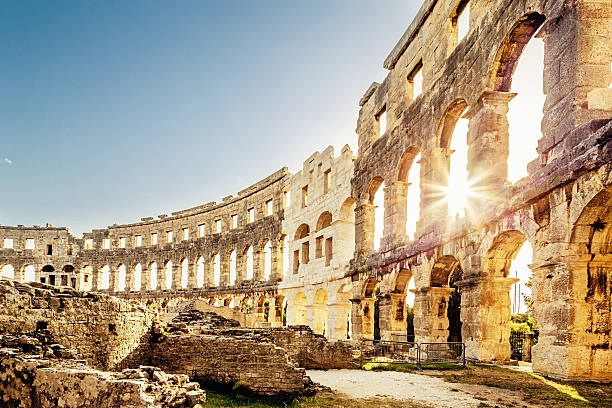 Amphitheater Pula,Croatia Landmark Roman Amphitheater in Pula Croatia. Built during 1st century AD, the amphitheater is the sixth largest in the world and has well preserved outer walls. Interior view with sun shining through arches into the roman colosseum. City of Pula, Croatia. croatia stock pictures, royalty-free photos & images