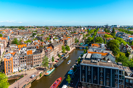 Roofs and facades of Amsterdam and the Prinsengracht. City view from the bell tower of the church Westerkerk, Holland, Netherlands. Lots of summer activity by people.