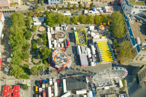 amusement park attractions in Jena, Germany. People coming for pleasure and entertainment. Colorful  carnival rides on a small park on the market of Jena. And various mechanical devices for riding on. Photo taken from the Jentower, 128m high.