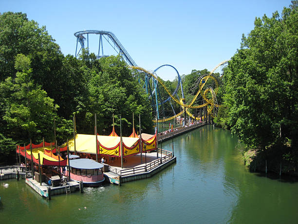 Amusement park by the water with ferries Roller Coaster and river boat ride at Busch Gardens in Williamsburg, Virginia on a sunny day. williamsburg virginia stock pictures, royalty-free photos & images