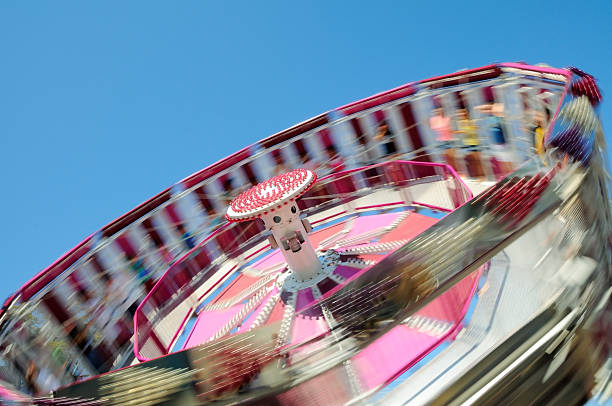 Amusement Park Ride Amusement park ride. People spinning and having fun outdoors. zero gravity carnival ride stock pictures, royalty-free photos & images