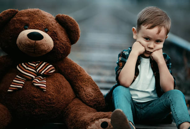 terk edilmiş evsiz bir çocuk yetimdir. yalnız bir çocuk tren rayları üzerinde oturur ve üzgün. i̇şlevsiz bir aile. - teddy ray stok fotoğraflar ve resimler