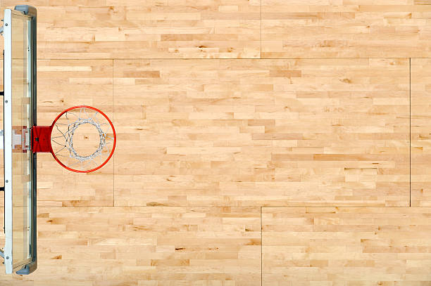 An aerial view of a basket rim and the floor Looking down on a basketball floor and Hoop. basketball court stock pictures, royalty-free photos & images