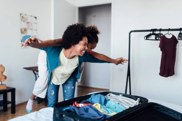 een afrikaanse amerikaanse familie die zich voor een vakantie maakt - packing suitcase stockfoto's en -beelden