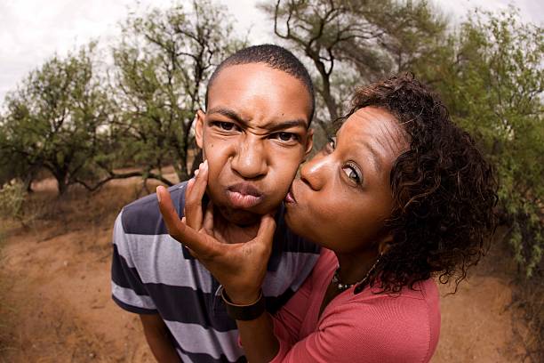 An African-American family making silly faces together single-parent mom and son being silly outdorrs embarrassment photos stock pictures, royalty-free photos & images