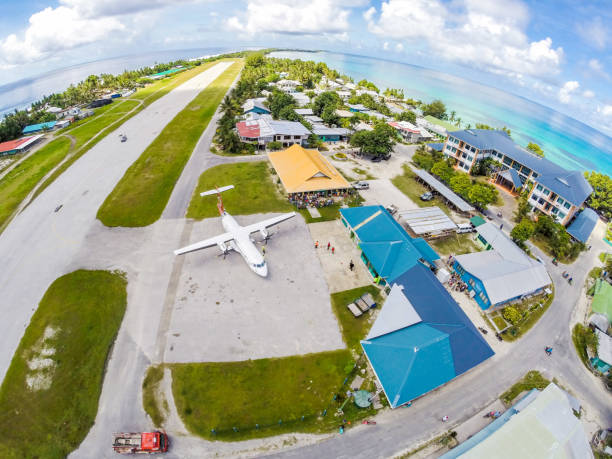 An airplane on the apron of Tuvalu international airport, just arrived. Vaiaku, Funafuti atoll, Polynesia, South Pacific Ocean, Oceania. Aerial view. stock photo