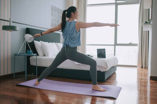 An asian chinese young woman practicing yoga exercising at home bedroom e learning using laptop online class  asian yoga pants stock pictures, royalty-free photos & images