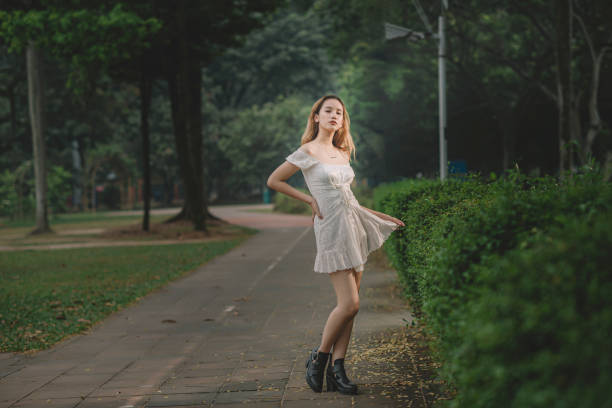 an asian female teenager girl standing at the park looking at camera an asian female teenager girl standing at the park looking at camera girls in very short dresses stock pictures, royalty-free photos & images