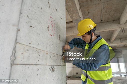 istock An Asian female worker works with pliers on the wall of the construction site 1420600450