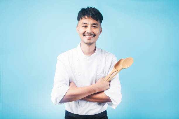 ein asiatischer männlicher kochgrauhintergrund - asiatischer koch stock-fotos und bilder