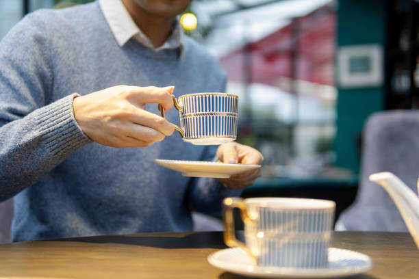 An Asian man drinking tea with English afternoon tea set stock photo