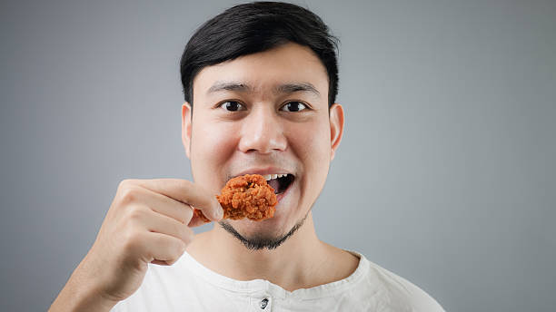 An Asian man with fried chicken. stock photo