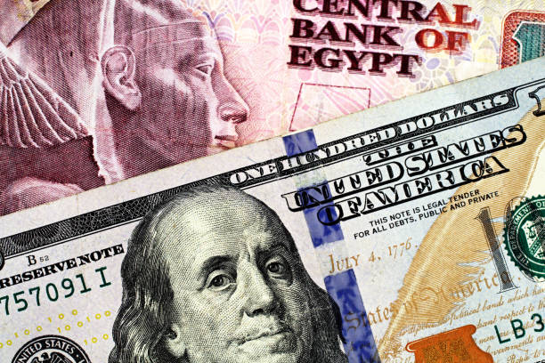 An Egyptian ten pound note with an American one hundred dollar bill stock photo