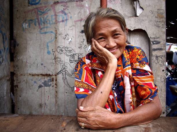 An elderly Asian woman smiles and pose for the camera. Antipolo City, Philippines - August 1, 2018: An elderly Asian woman smiles and pose for the camera. filipino woman stock pictures, royalty-free photos & images
