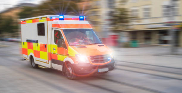 An emergency vehicle drives through the city with blue lights and high speed stock photo