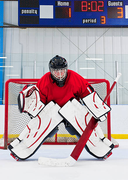 An ice hockey goalie defending his team's goal  Ice hockey goalie in front of his net. Picture taken on ice rink. hockey goalie stick stock pictures, royalty-free photos & images
