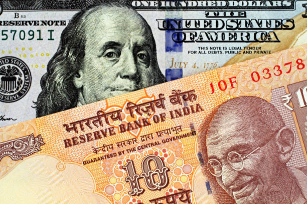 An Indian Ten Rupee Bank Note With An American One Hundred Dollar Bill stock photo