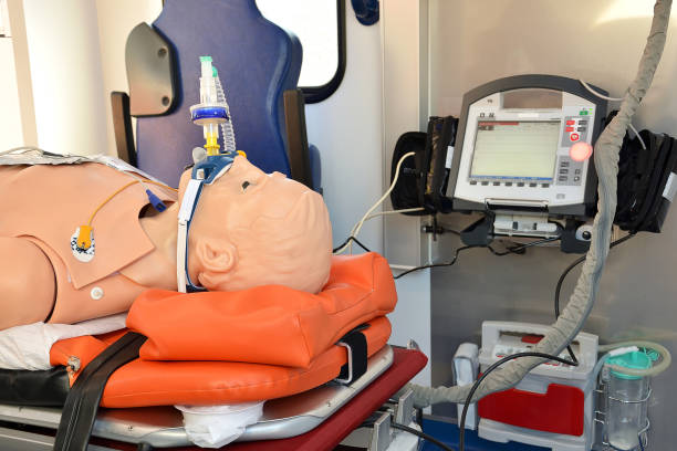 An intubated mannequin lies on a stretcher in an ambulance. In the background blood pressure vital sign ekg monitor. An intubated mannequin lies on a stretcher in an ambulance. In the background blood pressure vital sign ekg monitor. mannequin stock pictures, royalty-free photos & images
