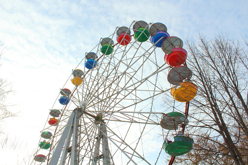 An old colored Ferris wheel in the city park. Close-up.