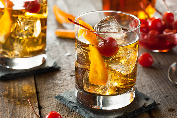 An old fashioned cocktail with cherries Homemade Old Fashioned Cocktail with Cherries and Orange Peel sour taste stock pictures, royalty-free photos & images