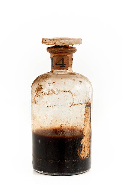 An old glass bottle half filled with brown poison stock photo