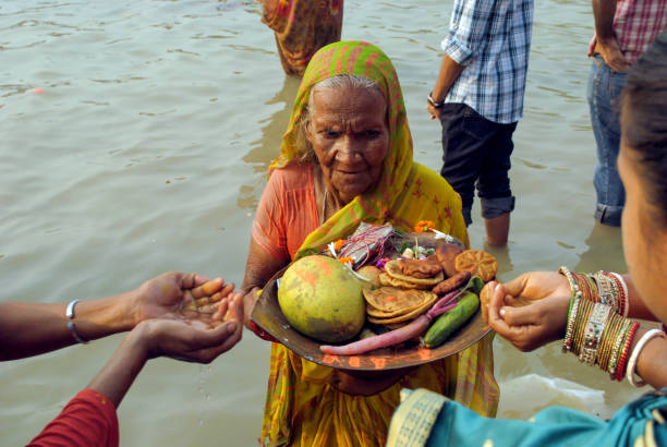 An old woman devotee was busy in performing rituals in Chhath festival. Kolkata west Bengal11.12.2010 an old woman devotee was busy in performing rituals in river water to celebrate Chhath festival. chhath stock pictures, royalty-free photos & images