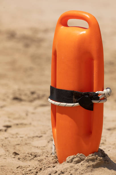 una boya de rescate naranja, volcada en la arena, españa. - public service fotografías e imágenes de stock