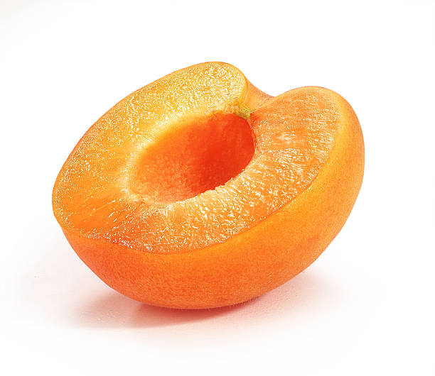 An ripe orange apricot cut in half apricot cut in half on white background apricot stock pictures, royalty-free photos & images