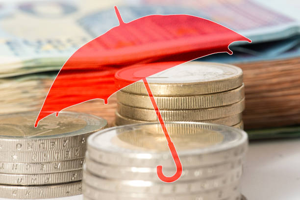 An umbrella and euro banknotes and coins stock photo