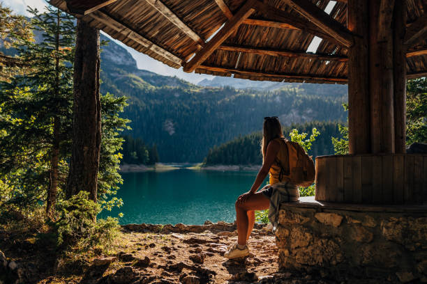 An unrecognizable woman sits in a summer house and rests after hard hiking. stock photo