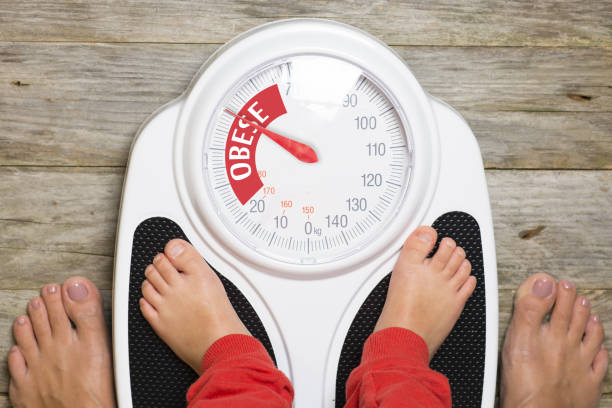 Analog bathroom scale indicating child obesity stock photo