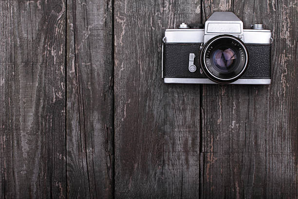 Analogue camera artistically placed on rustic wooden table stock photo