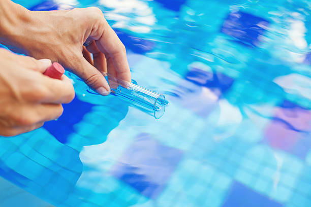 Analyzing of a water from swimming pool taking water sample to a flask (faceless, macro) standing water stock pictures, royalty-free photos & images