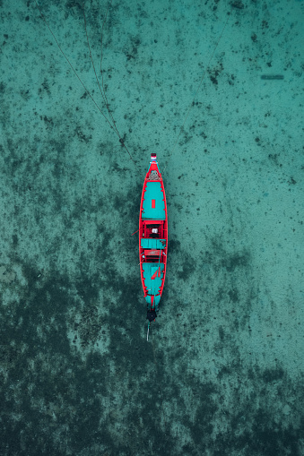 Aerial view of long tail boat anchored during low tide.