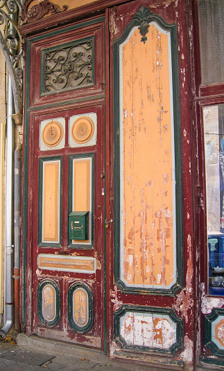 Vertical photo of an ancient peeling facade of painted wood. Photo taked to an old inactive store at L'isle-Sur-la-Sorgue - Avignon - France