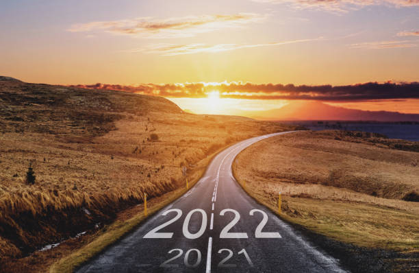 2022 and 2021 on the empty road at sunset. New Year concepts stock photo