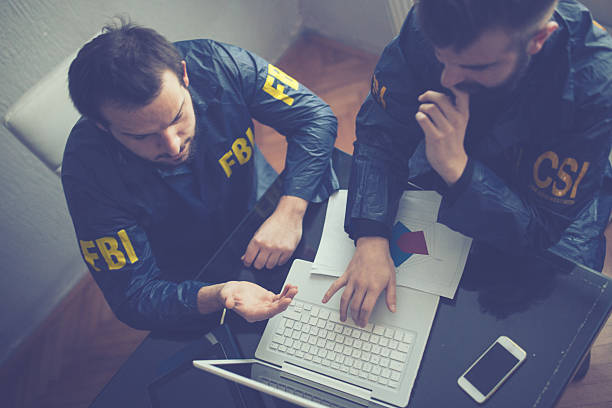 FBI and CSI agents FBI and CSI agents working in the office on a crime. they are working on laptop federal building stock pictures, royalty-free photos & images