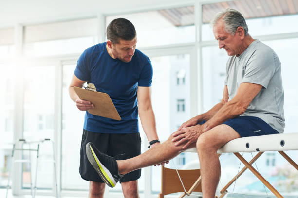 And it's the joint itself? Cropped shot of a handsome young male physiotherapist doing a consultation and assessment with a senior patient osteopathy stock pictures, royalty-free photos & images