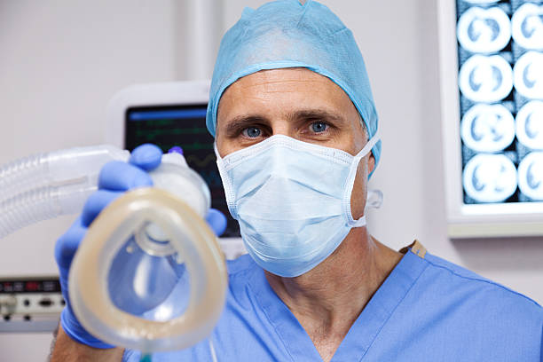 Anesthesiologist XXXL. Anesthesiologist with a breathing mask in an operating room.  Focus is on the anesthesiologist. gchutka stock pictures, royalty-free photos & images